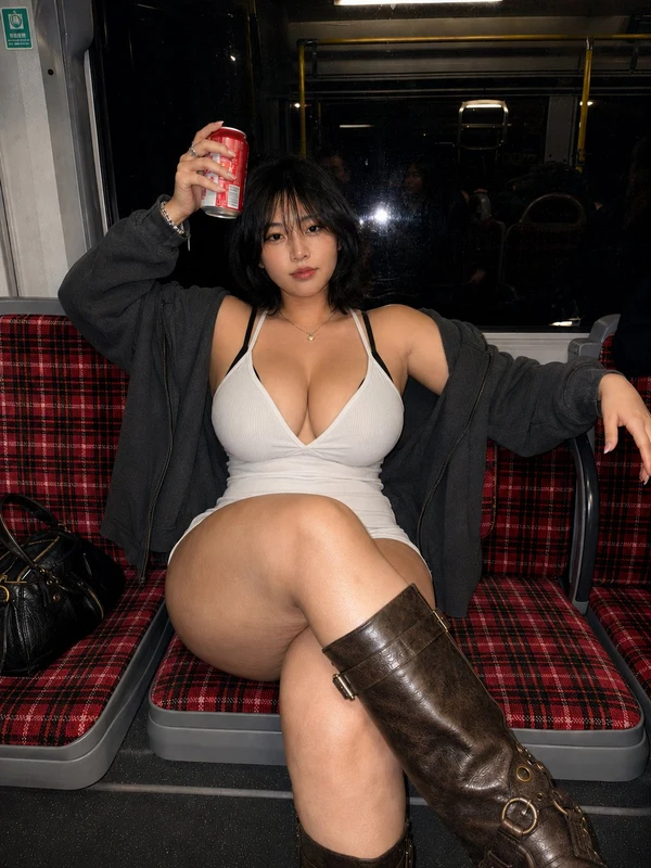 Woman in a dark top and skirt on a night bus